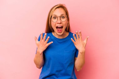 Pembe arka planda izole edilmiş genç beyaz kadın on numarayı elleriyle gösteriyor..