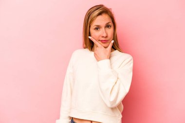 Pembe arka planda izole edilmiş genç beyaz kadın bir strateji planlıyor, bir iş kurmanın yollarını düşünüyor..