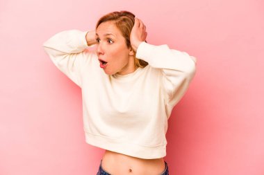 Pembe arka planda izole edilmiş genç beyaz kadın çığlık atıyor, çok heyecanlı, tutkulu, bir şeyden memnun..