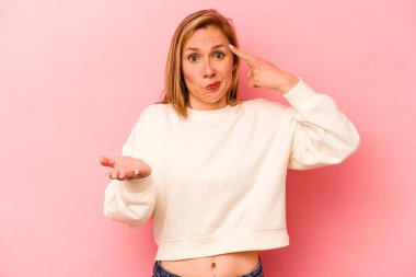 Pembe arka planda izole edilmiş beyaz bir kadın elinde bir ürün tutuyor..