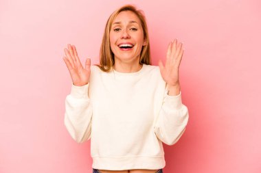 Pembe arka planda soyutlanmış beyaz bir kadın yüksek sesle gülüyor ve elini göğsüne koyuyor..