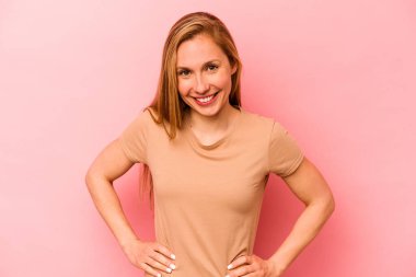 Pembe arka planda izole edilmiş genç beyaz kadın mutlu, güler yüzlü ve neşeli..