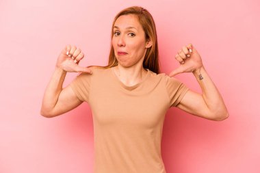 Pembe arka planda izole genç beyaz kadın gururlu ve kendinden emin hissediyor, örnek olarak..