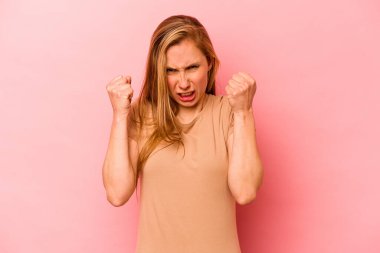 Pembe arka planda izole edilmiş genç beyaz kadın gergin elleriyle çığlık atıyor..