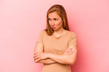 Pembe arka planda izole edilmiş genç beyaz kadın tekrarlanan bir görevden bıktı..