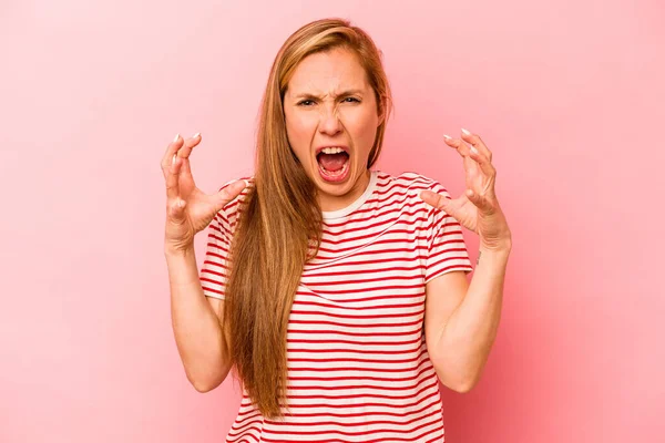 Pembe arka planda izole edilmiş beyaz bir kadın öfkeyle bağırıyor..