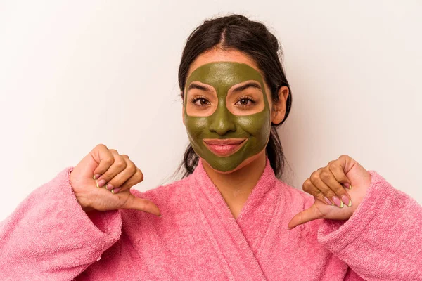 Beyaz arka planda izole edilmiş yüz maskesi takan genç İspanyol kadın gururlu ve kendinden emin hissediyor, örnek olarak..