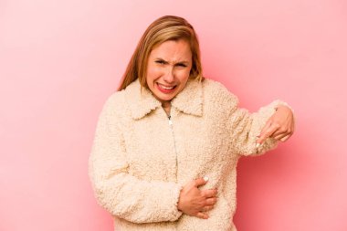 Pembe arka planda karaciğer ağrısı çeken, karnı ağrıyan beyaz bir kadın..