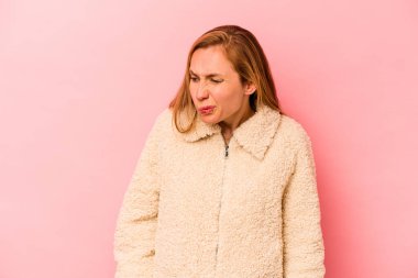 Pembe arka planda soyutlanmış beyaz bir kadın omuzlarını silkeliyor ve gözleri açık..