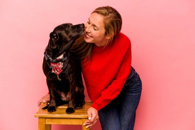 Pembe arka planda köpeği olan beyaz bir kadın.