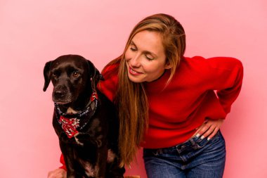 Pembe arka planda köpeği olan beyaz bir kadın.