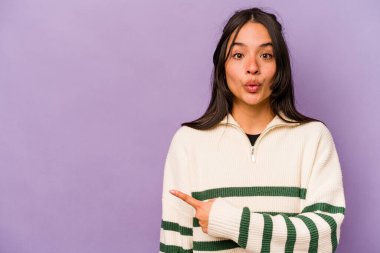 Mor arka planda izole edilmiş genç İspanyol kadın yan tarafı gösteriyor.