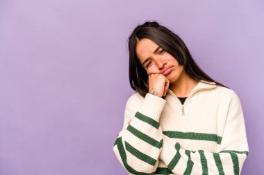 Mor arka planda izole edilmiş, üzgün ve dalgın hisseden, kopyalama alanına bakan genç İspanyol kadın..