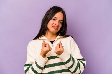 Mor arka planda izole edilmiş genç İspanyol kadın parasız olduğunu gösteriyor..