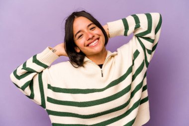 Mor arka planda izole edilmiş genç İspanyol kadın. Kollarını uzatıyor, rahat duruyor..