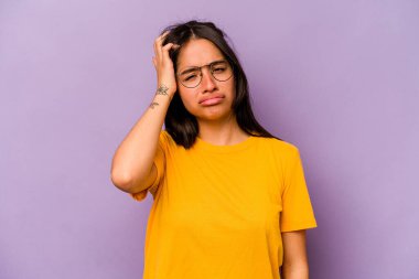 Mor arka planda izole edilmiş genç İspanyol kadın yorgun ve uykulu ellerini başının üstünde tutuyor..