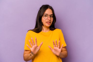 Mor arka planda izole edilmiş genç İspanyol kadın tiksinti belirtisi gösteren birini reddediyor..