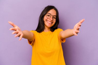 Mor arka planda izole edilmiş genç İspanyol kadın kameraya sarıldığı için kendinden emin..