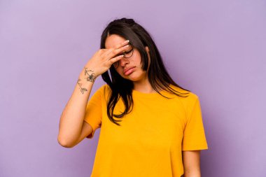 Mor arka planda izole edilmiş genç İspanyol kadın başı ağrıyor, yüzüne dokunuyor..