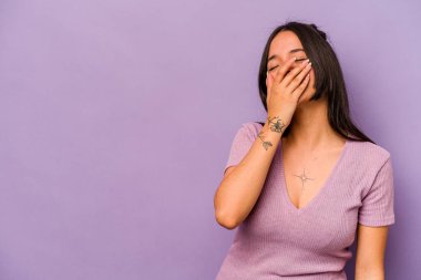 Mor arka planda izole olmuş genç İspanyol kadın gülüyor, kaygısız, doğal duygu..