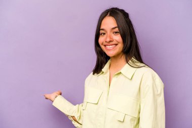 Mor arka planda izole edilmiş genç İspanyol kadın hoş bir ifade sergiliyor..