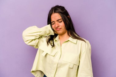 Mor arka planda izole edilmiş genç İspanyol kadın yorgun ve uykulu ellerini başının üstünde tutuyor..