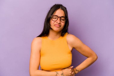 Mor arka planda karaciğer ağrısı çeken, karnı ağrıyan genç bir İspanyol kadın..