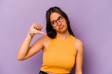 Mor arka planda izole edilmiş genç İspanyol kadın hoşlanmadığı bir hareket gösteriyor. Anlaşmazlık konsepti.