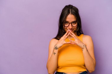 Genç İspanyol kadın, mor arka planda izole edilmiş. Aklında bir plan kuruyor, bir fikir kuruyor..