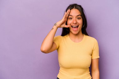 Mor arka planda izole edilmiş genç İspanyol kadın yüksek sesle bağırıyor, gözleri açık ve elleri gergin tutuyor..