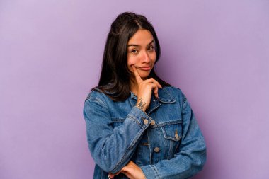 Latin kökenli genç bir kadın, mor arka planda izole edilmiş. Bir strateji planlıyor, bir iş yolu düşünüyor..