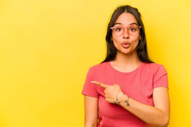 Sarı arka planda izole edilmiş genç İspanyol kadın...