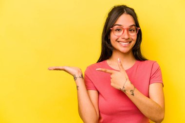 Sarı arka planda izole edilmiş genç İspanyol bir kadın..