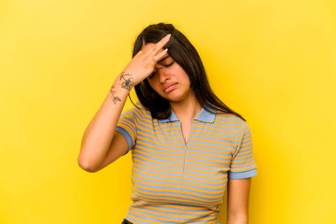 Sarı arka planda izole edilmiş genç İspanyol kadın başı ağrıyor, yüzüne dokunuyor..