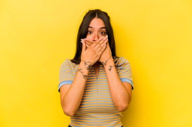 Sarı arka planda izole edilmiş genç İspanyol kadın elleri endişeli görünüyor..