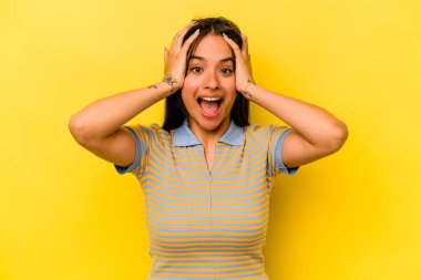 Genç İspanyol kadın sarı arka planda izole edilmiş bağırıyor, çok heyecanlı, tutkulu, bir şeyden memnun..