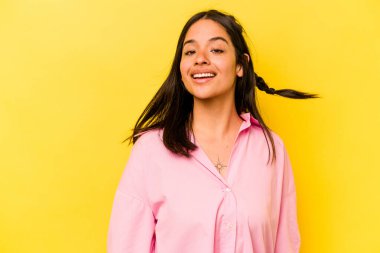 Sarı arka planda yalnız yaşayan genç İspanyol kadın dans ediyor ve eğleniyor..