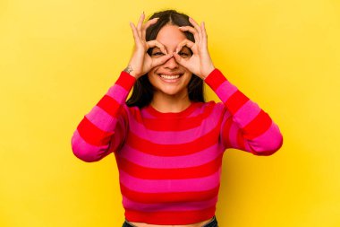 Sarı arka planda izole edilmiş genç bir İspanyol kadın heyecanlı..