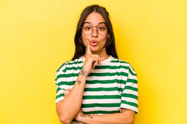 Sarı arka planda izole edilmiş genç İspanyol bir kadının harika bir fikri var, yaratıcılık kavramı..