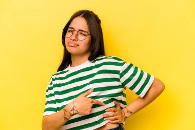 Sarı arka planda karaciğer ağrısı çeken, karnı ağrıyan genç bir İspanyol kadın..