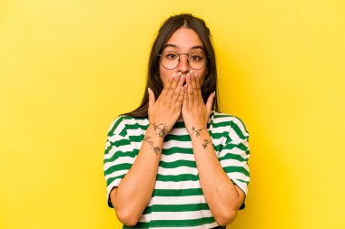 Sarı arka planda izole edilmiş genç İspanyol kadın elleri endişeli görünüyor..