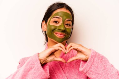 Beyaz arka planda izole edilmiş yüz maskesi takan genç İspanyol kadın.