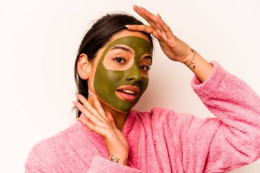 Beyaz arka planda izole edilmiş yüz maskesi takan genç İspanyol kadın.