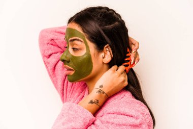 Beyaz arka planda izole edilmiş yüz maskesi takan genç İspanyol kadın.