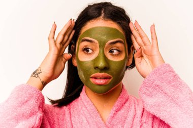 Beyaz arka planda izole edilmiş yüz maskesi takan genç İspanyol kadın.