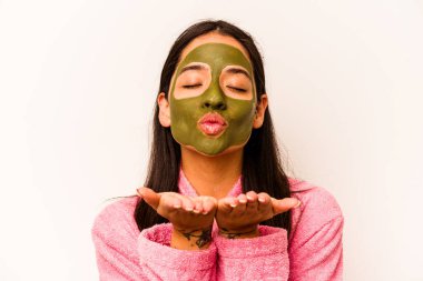 Beyaz arka planda izole edilmiş yüz maskesi takan genç İspanyol kadın.