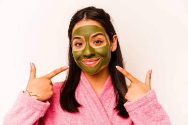 Beyaz arka planda izole edilmiş yüz maskesi takan genç İspanyol kadın.