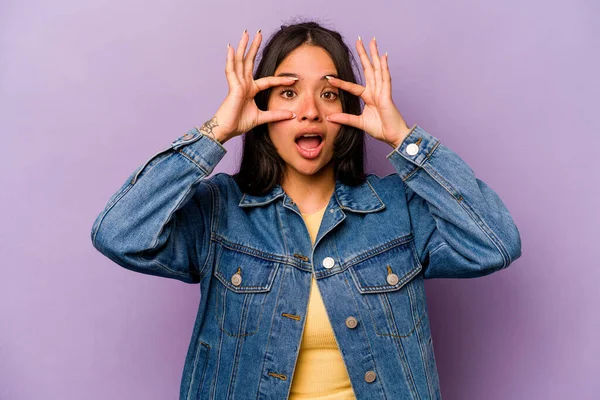 Mor arka planda izole edilmiş genç İspanyol kadın başarı fırsatı bulmak için gözlerini açık tutuyor..