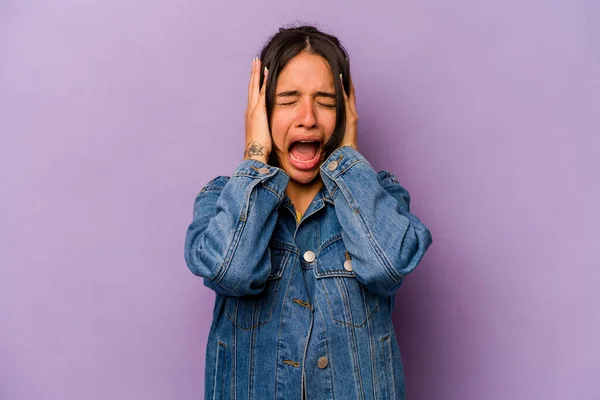 若いですヒスパニック系の女性は紫の背景に耳をカバー手であまりにも大きな音を聞かないようにしようとします — ストック写真