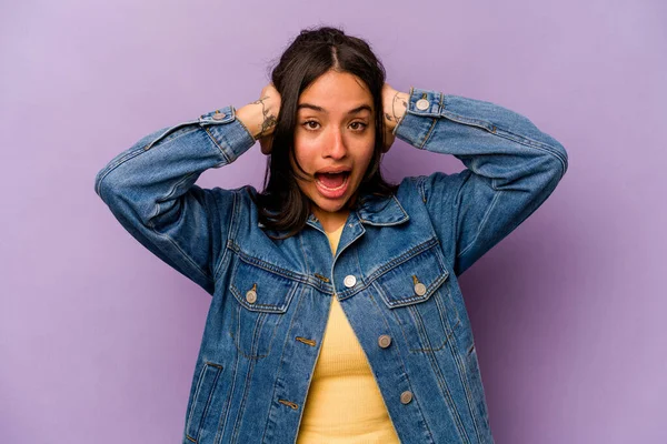 Genç İspanyol kadın mor arka planda izole edilmiş bağırıyor, çok heyecanlı, tutkulu, bir şeyden memnun..